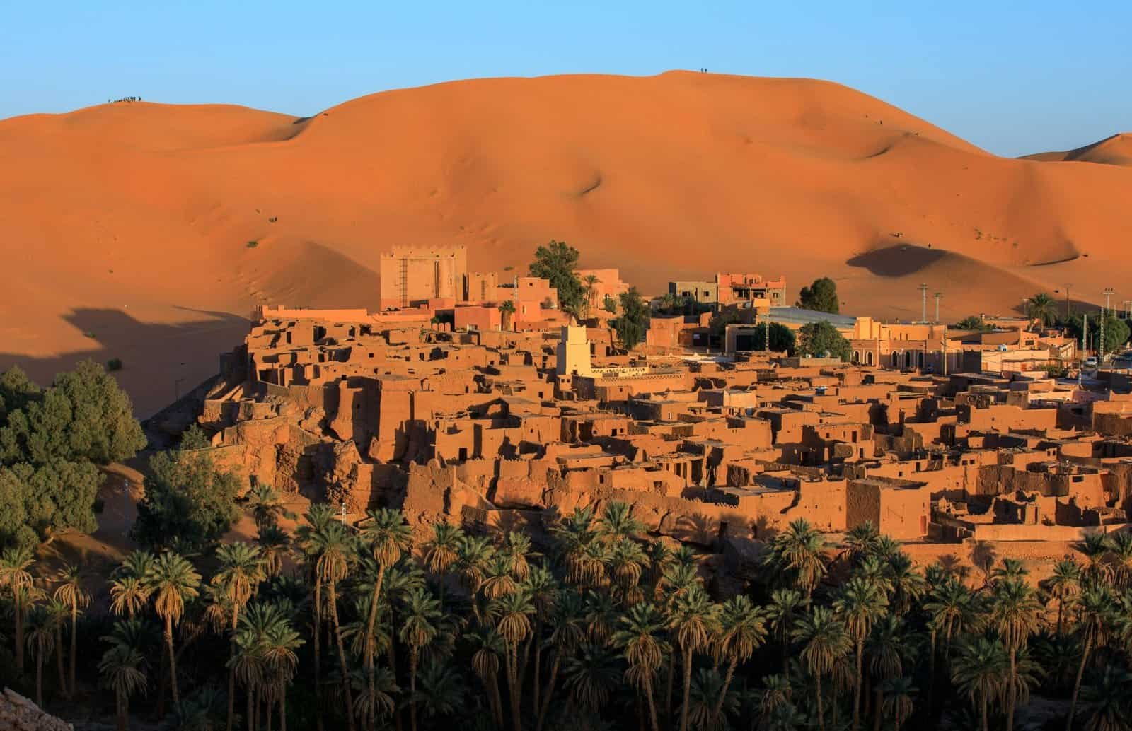 A stunning view of Taghit village and sand dunes in Algeria at sunset.