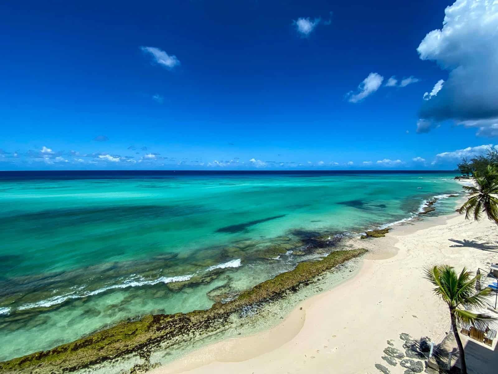 A breathtaking aerial view of a serene tropical beach with clear turquoise waters and blue sky.